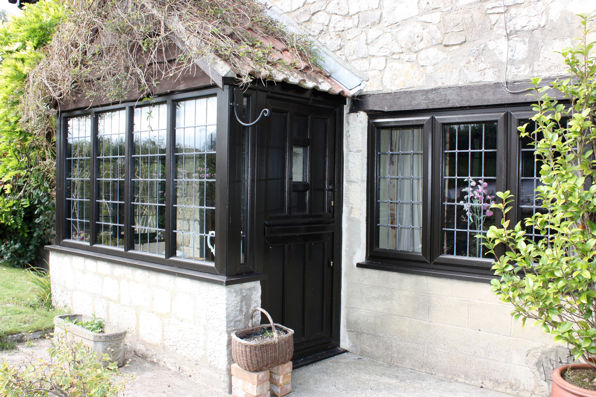 black-wood-effect-upvc-windows-with-thatched-roof
