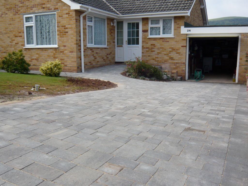 Grey block paved driveway in Somerset in front of bungalow and leading to garage