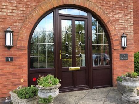 PVCu front door set against a traditional brick wall.